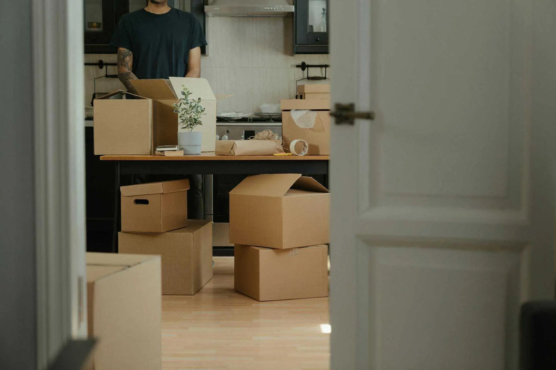 A person unpacking boxes in a new home, symbolizing the transition and mindset shifts of relocation.