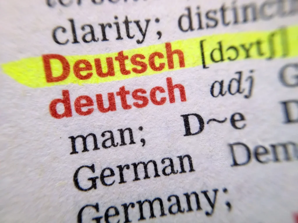 Person sitting alone in Berlin cafe while group of Germans converse in background, symbolizing language barrier and isolation after 6 months without learning German